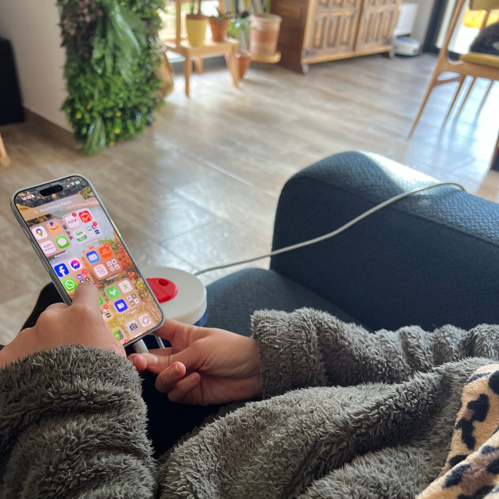 Utilisation de la bobine branchée avec un câble USB-C de 5 mètres qui charge un iPhone sur un canapé