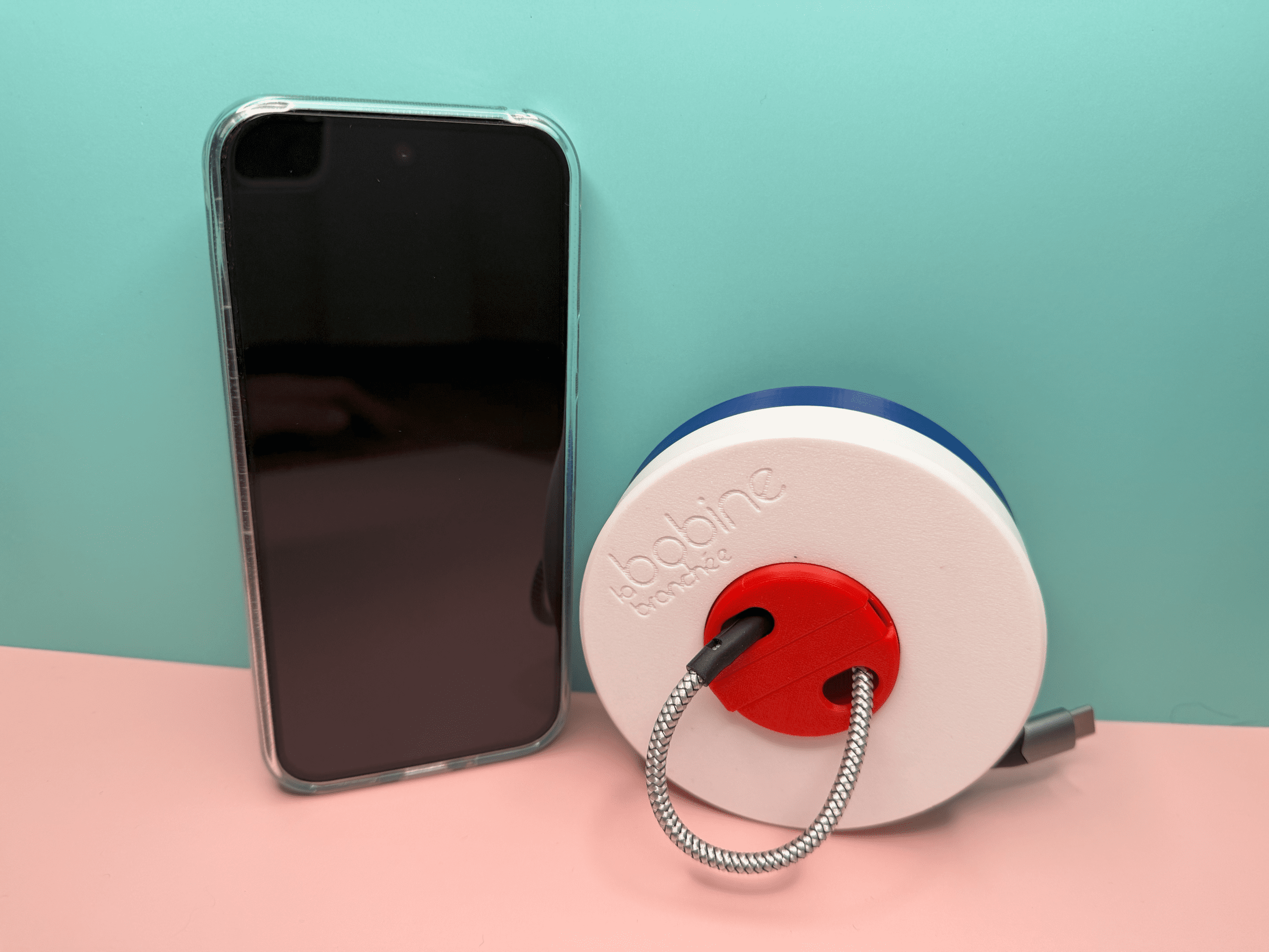 Comparaison de la taille de la bobine branchée avec un smartphone de taille standard